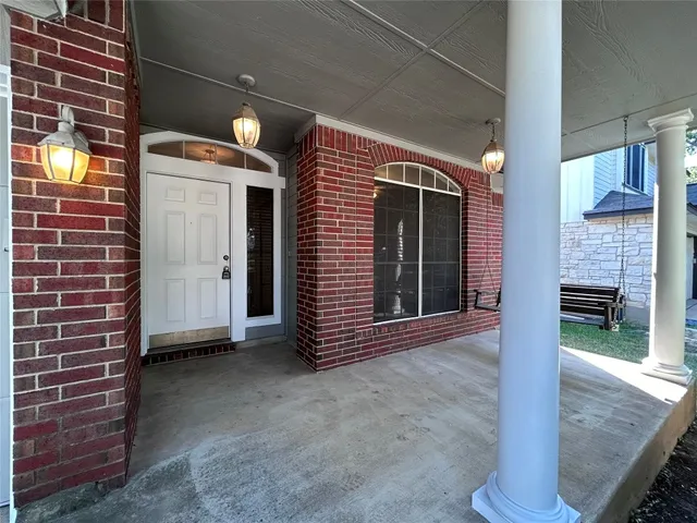 a view of a brick house with entryway doors