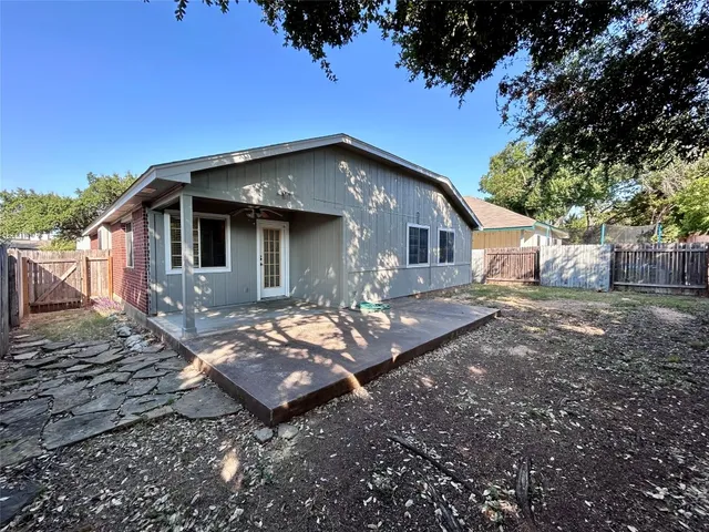 a view of a house with backyard and trees