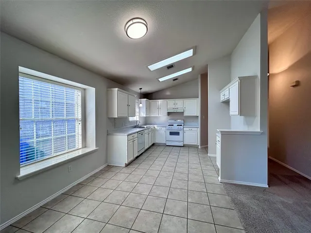 a kitchen with stainless steel appliances a cabinets and window