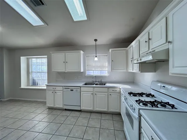 a kitchen with cabinets a sink and appliances
