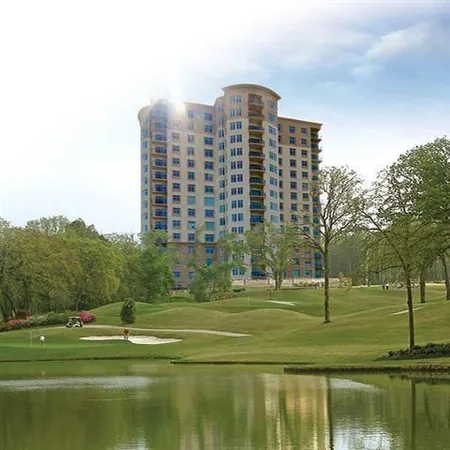 a view of a big building with a big yard and large trees