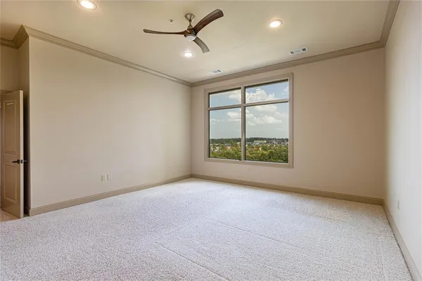 en empty room with windows and ceiling fan