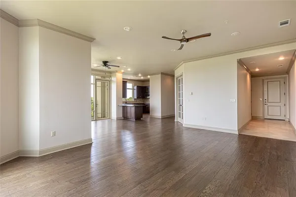 a view of a kitchen with a fridge and wooden floor
