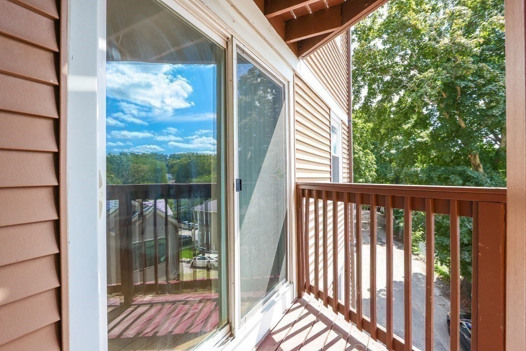 306 Tappan Street, Unit B Brookline, MA 02445 - Photo 27 of 35 a view of a balcony with a floor to ceiling window and wooden fence