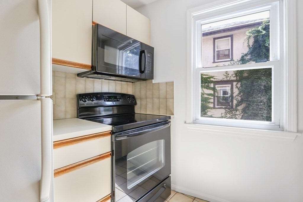 306 Tappan Street, Unit B Brookline, MA 02445 - Photo 9 of 35 a kitchen with a stove and a microwave