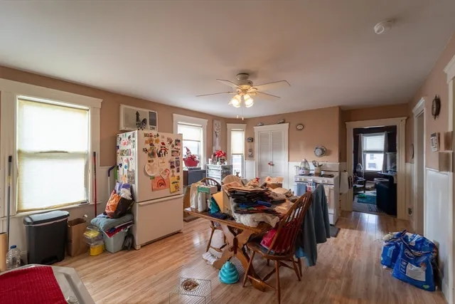 a view of a dining room and livingroom with furniture wooden floor a chandelier