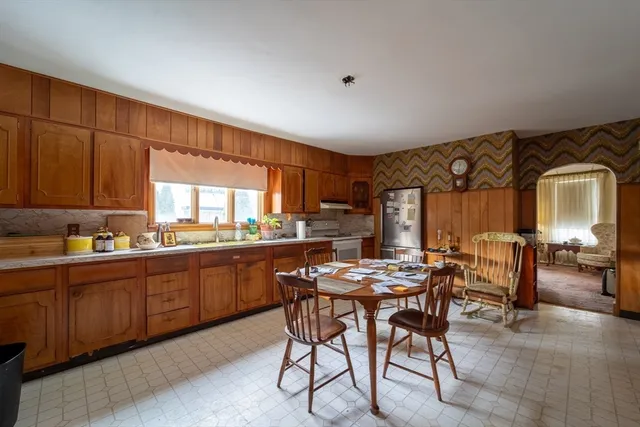 a kitchen with a table chairs and wooden cabinets