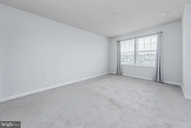 a spacious bedroom with a bed and a window