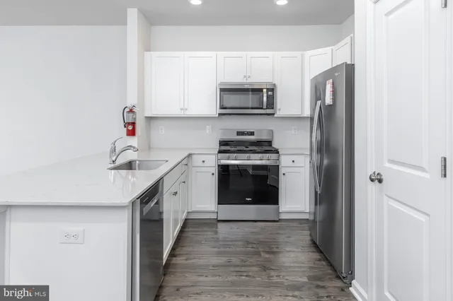 a kitchen with stainless steel appliances a sink dishwasher a stove and a refrigerator