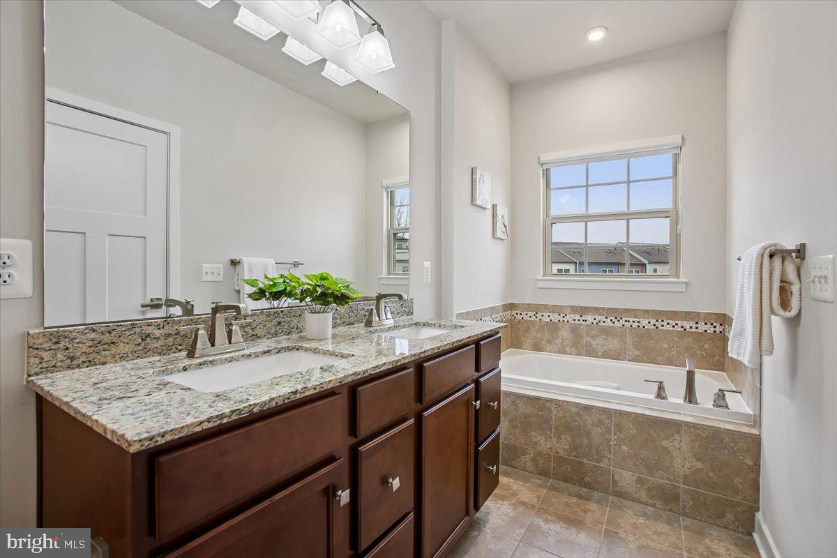 2105 Hemlock Bay Road Dumfries, VA 22026 - Photo 13 of 48 a bathroom with a granite countertop bathtub and a sink