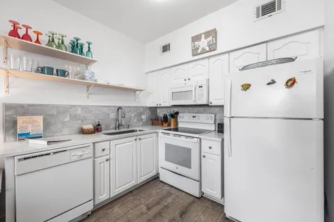 a kitchen with white cabinets and white appliances