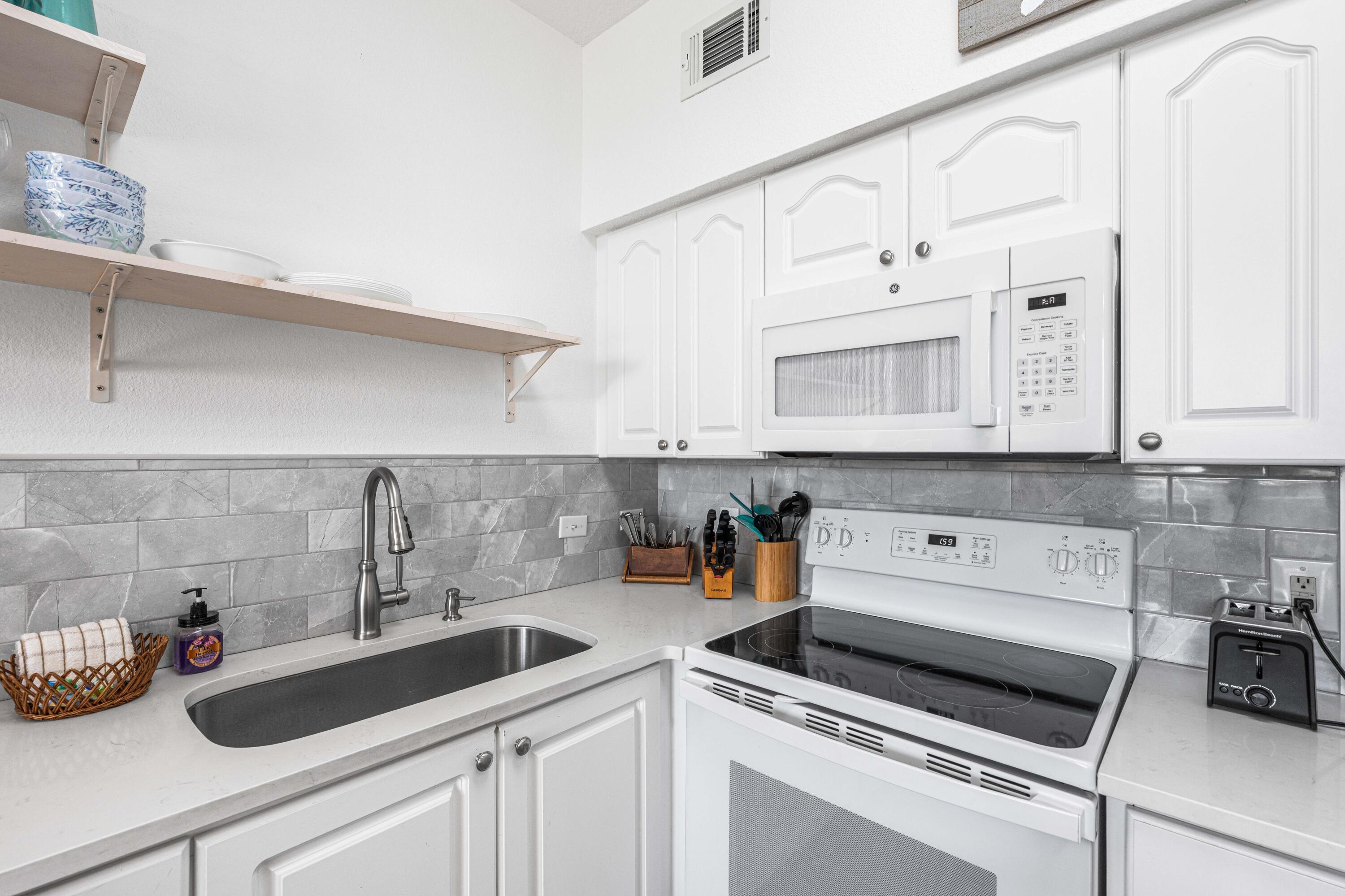 145 Spires Lane, Unit 306 Santa Rosa Beach, FL 32459 - Photo 19 of 35 a kitchen with white cabinets and sink
