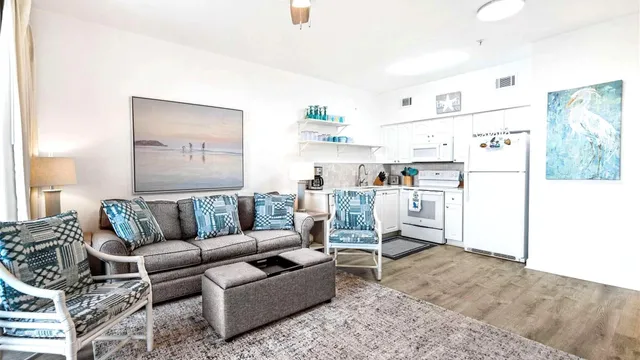 a living room with furniture and a refrigerator
