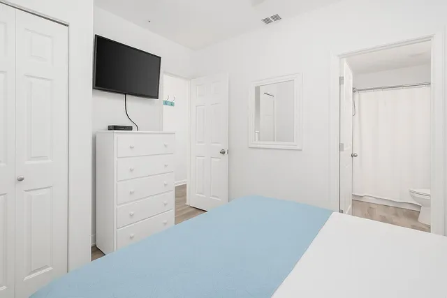 a bedroom with a bed and a flat screen tv