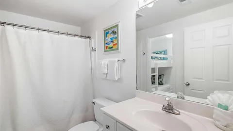 a bathroom with a sink a toilet and shower curtain
