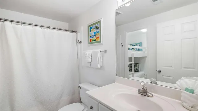 a bathroom with a sink a toilet and shower curtain