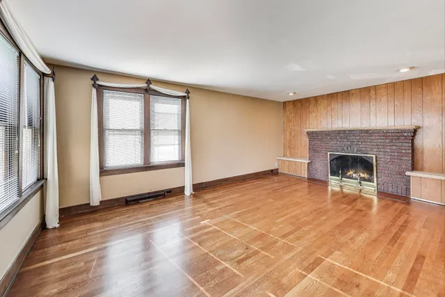 a view of a livingroom with wooden floor and a fireplace