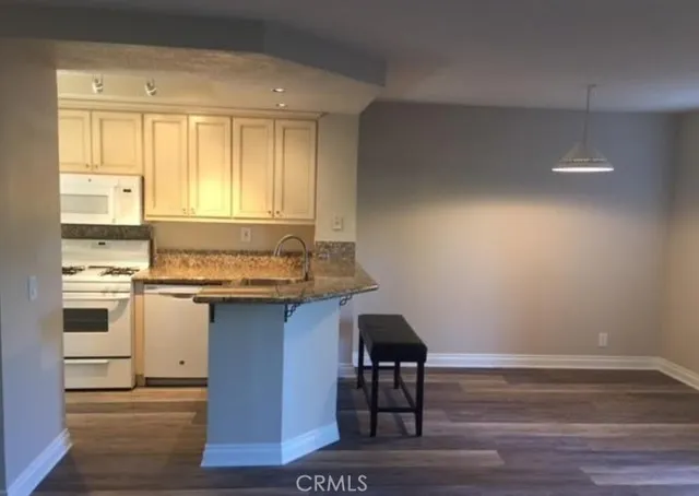 a kitchen with a sink cabinets and wooden floor