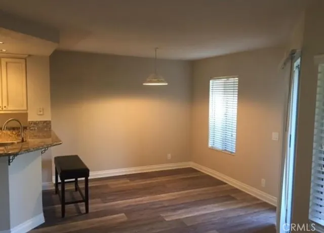 a view of a livingroom with wooden floor and a window