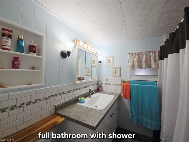 a bathroom with a sink a mirror and a shower