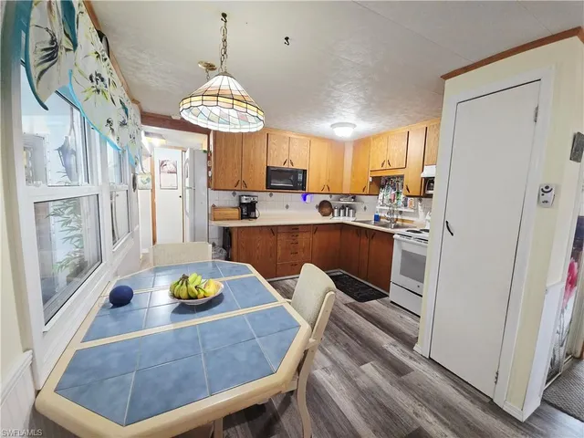 a kitchen with stainless steel appliances a dining table chairs and chandelier