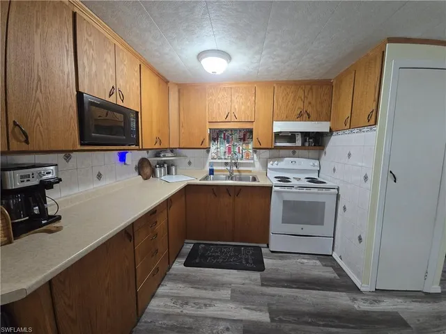 a kitchen with a sink stove and refrigerator