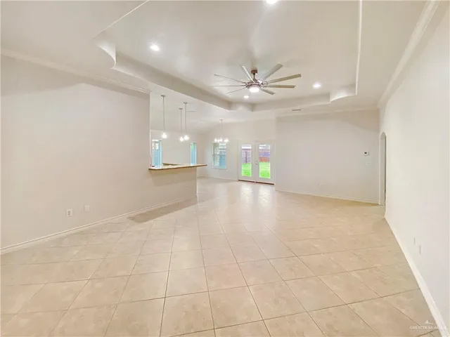an empty room with a ceiling fan and a rug