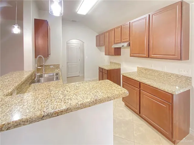 a kitchen with stainless steel appliances granite countertop a sink stove and cabinets