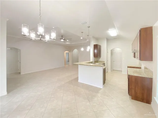 a view of a kitchen with granite countertop wooden floor and stainless steel appliances