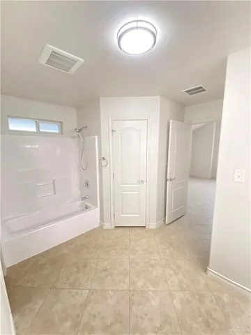 a view of an empty room and a bathroom