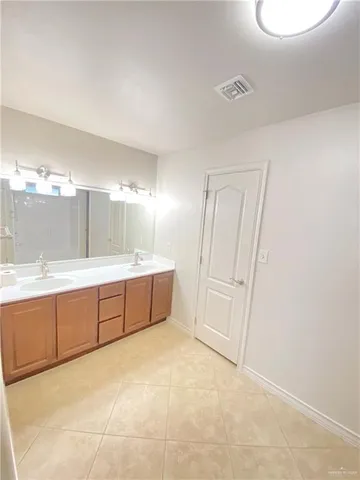 a spacious bathroom with a granite countertop sink a mirror and a bathtub
