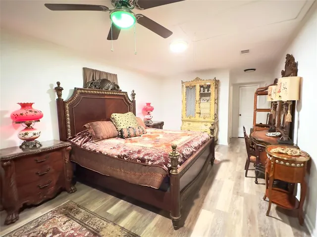a bedroom with bed and wooden floor