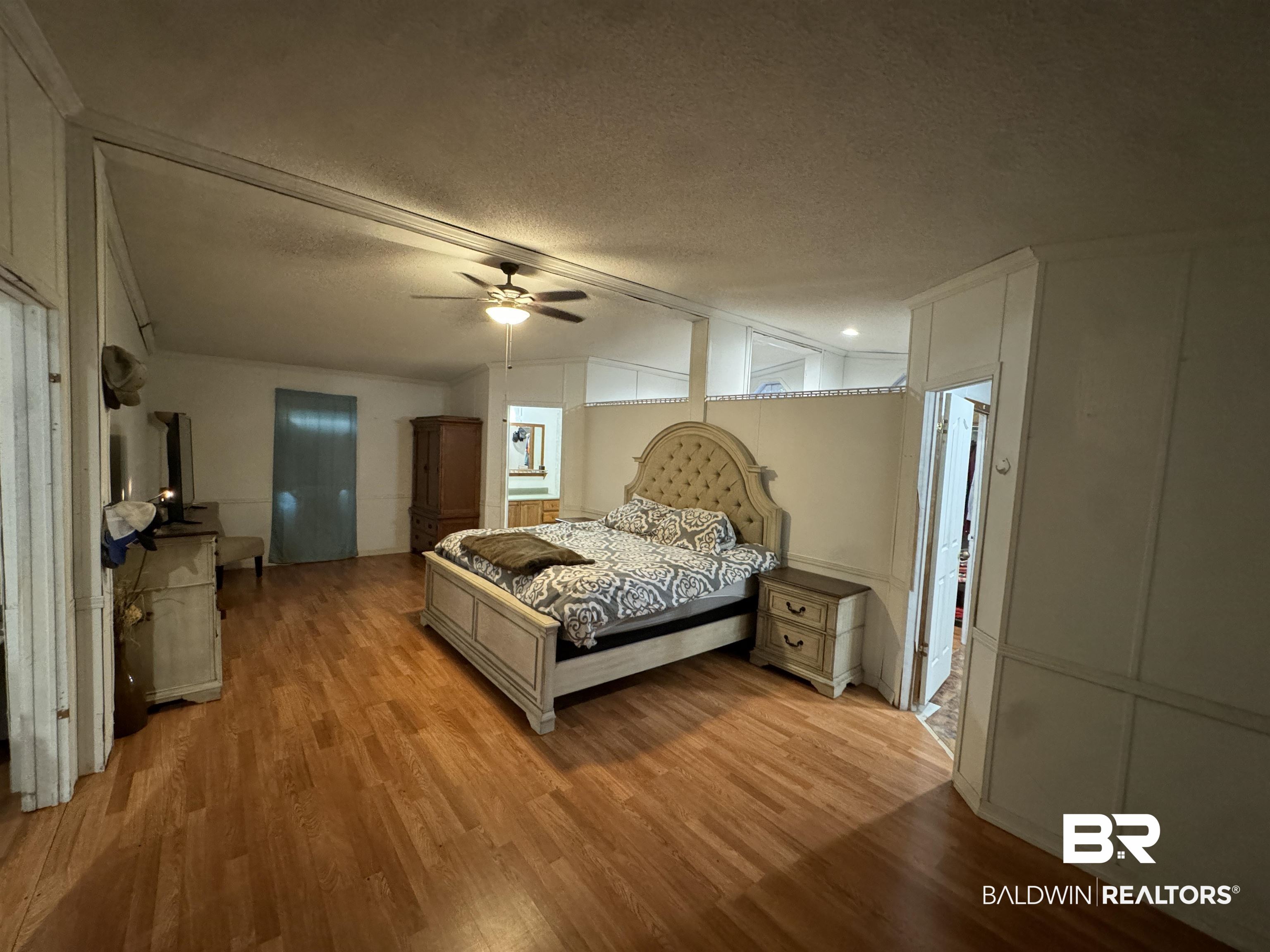 51235 Phillipsville Road Bay Minette, AL 36507 - Photo 26 of 63 Bedroom featuring a textured ceiling, a decorative wall, wood finished floors, and ceiling fan