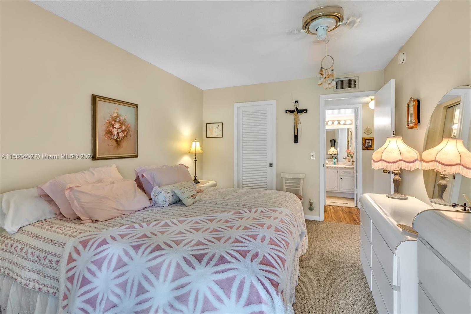 2011 Lyndhurst H, Unit 2011 Deerfield Beach, FL 33442 - Photo 17 of 35 a bedroom with a large bed and a chandelier