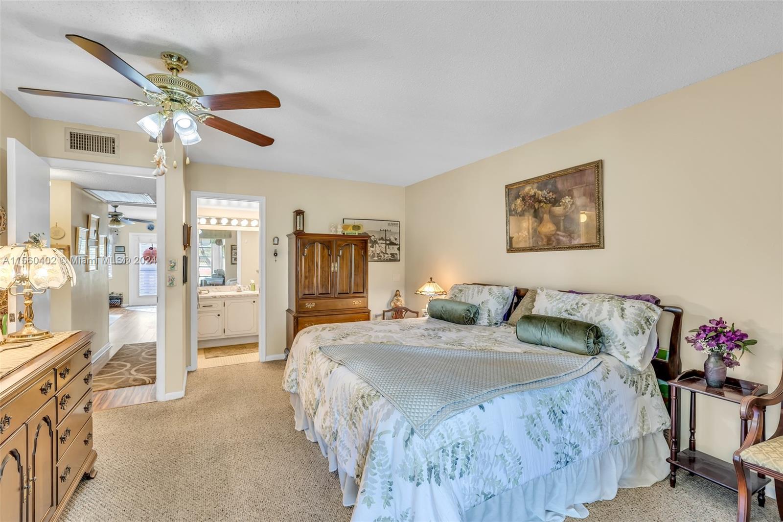 2011 Lyndhurst H, Unit 2011 Deerfield Beach, FL 33442 - Photo 21 of 35 a bedroom with a bed and a chandelier