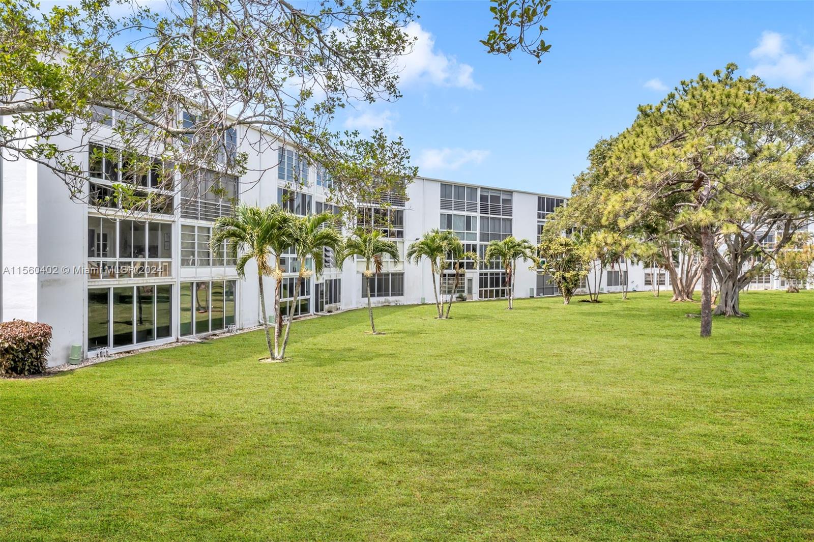 2011 Lyndhurst H, Unit 2011 Deerfield Beach, FL 33442 - Photo 32 of 35 a swimming pool with outdoor seating and yard