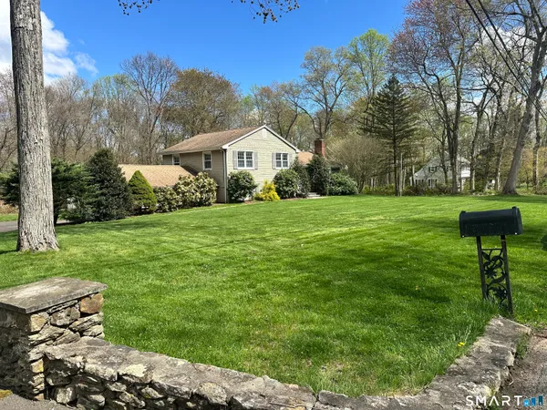 a front view of a house with a yard and trees