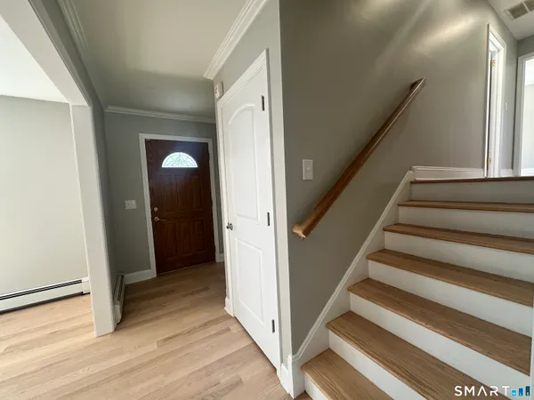 a view of entryway with wooden floor and stairs