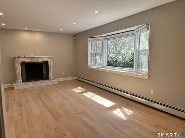 an empty room with windows and fireplace