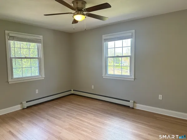 an empty room with window and wooden floor