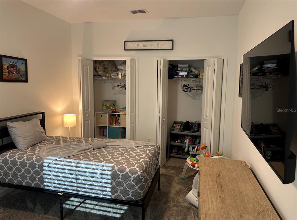 2759 Slash Way St. Cloud, FL 34771 - Photo 29 of 45 a bedroom with a bed and dresser with mirror