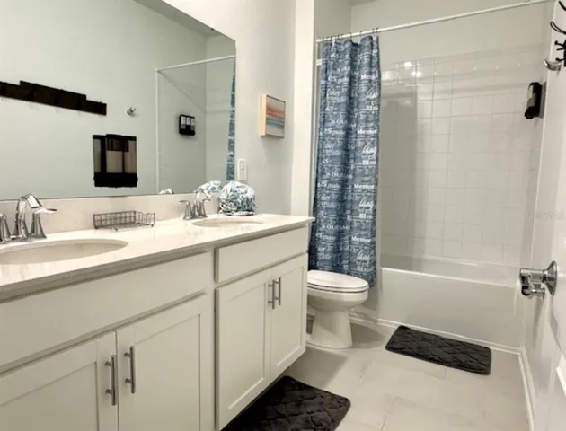 a bathroom with a double vanity sink toilet and shower