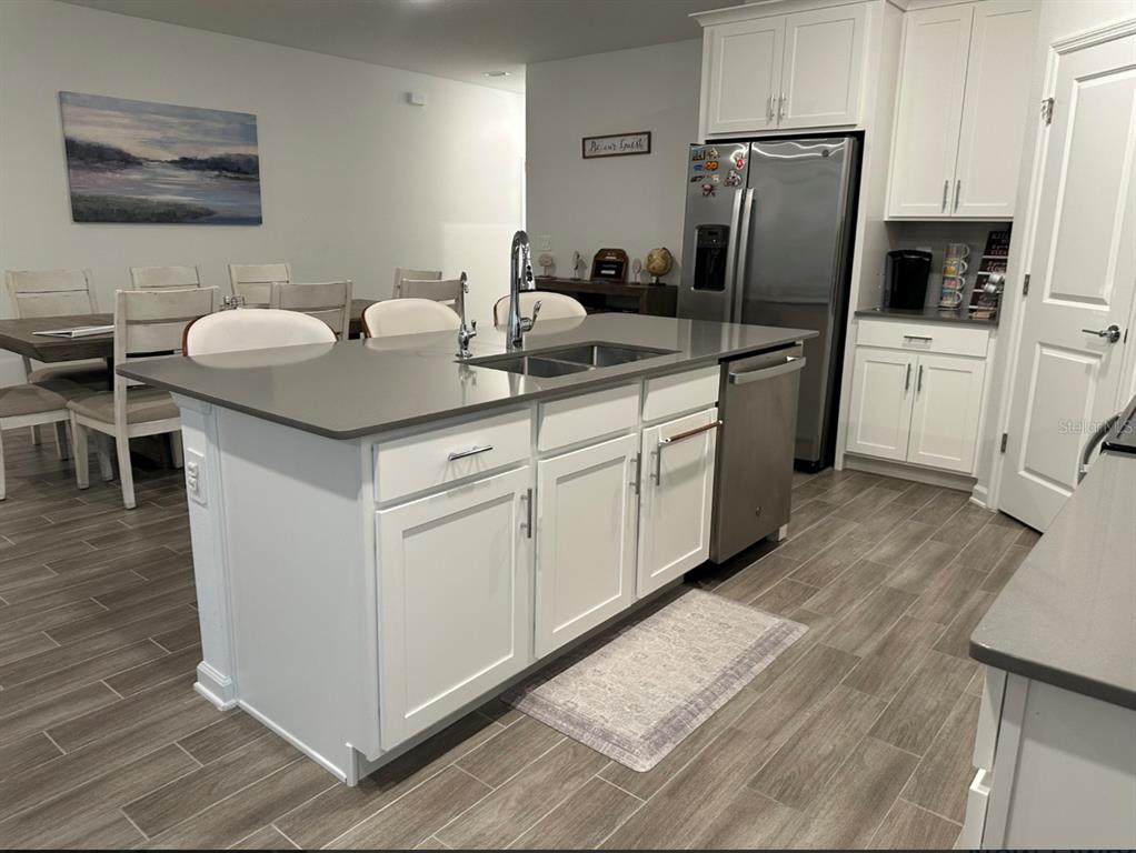 2759 Slash Way St. Cloud, FL 34771 - Photo 6 of 45 a kitchen with white cabinets and stainless steel appliances