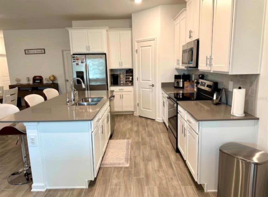2759 Slash Way St. Cloud, FL 34771 - Photo 7 of 45 a kitchen with kitchen island granite countertop a sink a counter top space cabinets and stainless steel appliances