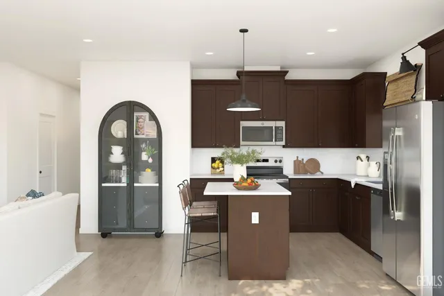a kitchen with stainless steel appliances kitchen island a refrigerator a sink and a stove