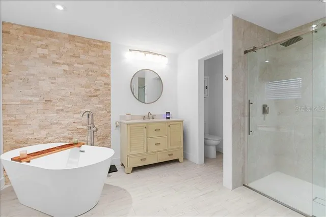 a bathroom with a tub sink shower and mirror