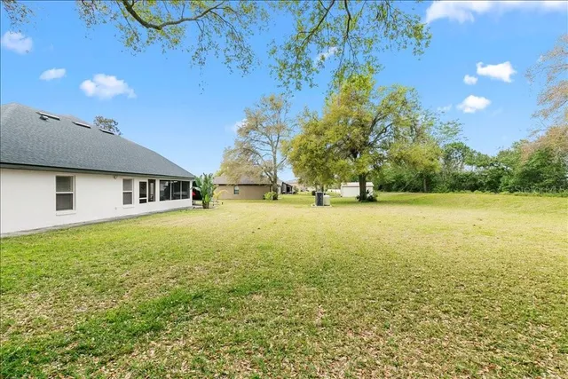 a front view of house with yard and trees in the background