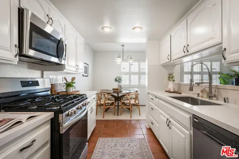 a kitchen with white cabinets and counter space