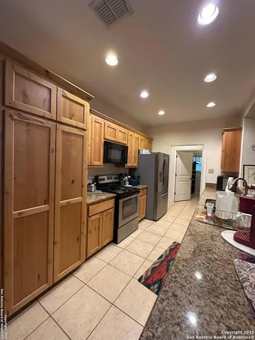 a kitchen with stainless steel appliances granite countertop a refrigerator and microwave
