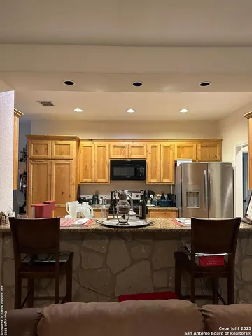 a living room with stainless steel appliances kitchen island granite countertop furniture and a large window